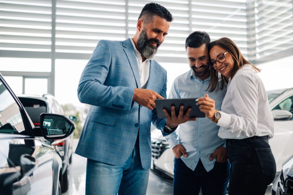 Trio discussing car purchase options using a digital platform